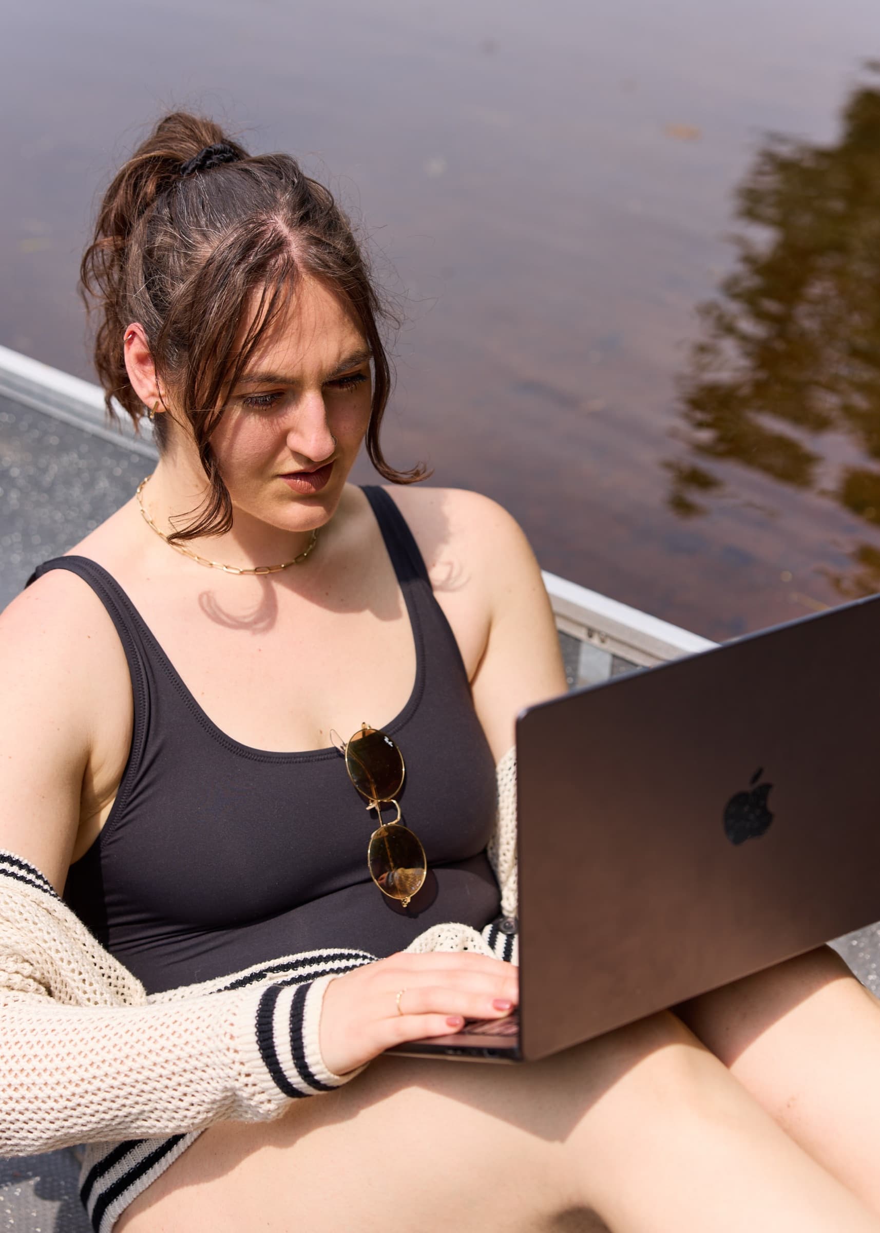 A founder working on a laptop by the water while a design partner leads the brand process
