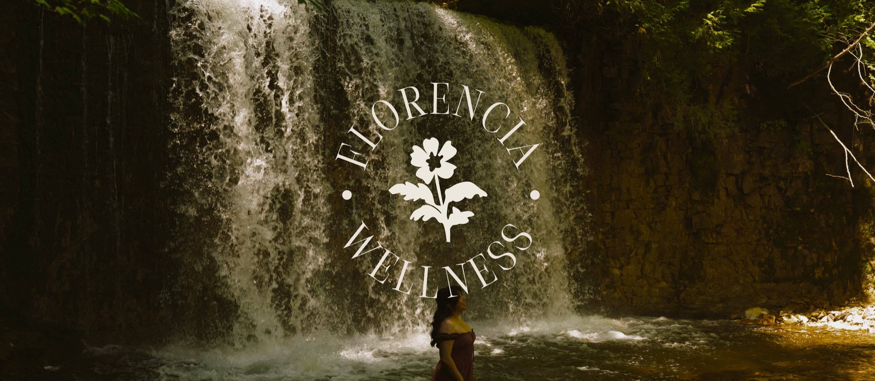 Florencia Wellness circular flower seal over a woman at the base of a golden waterfall